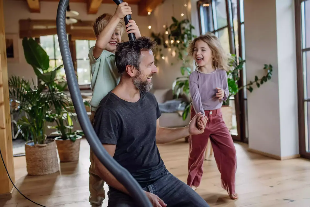 Dad and kids cleaning a pest-free living room, pest control in Warner